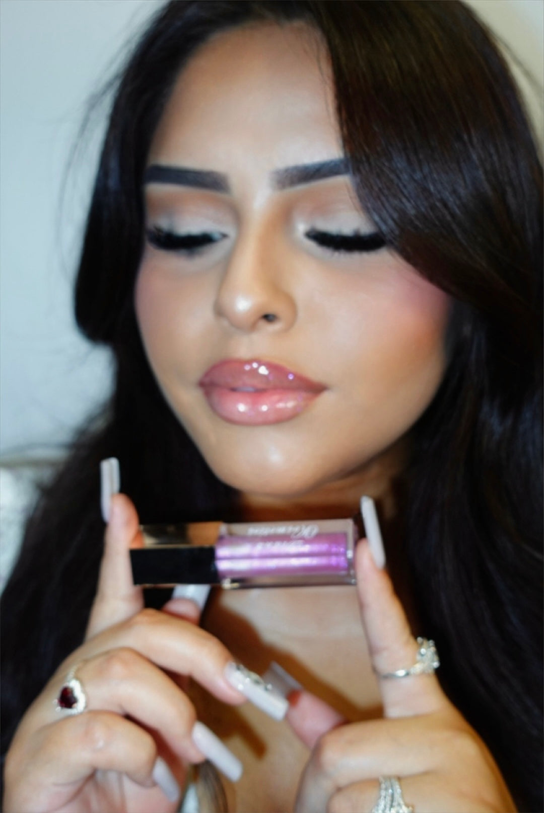 Woman holding a makeup product with a blurred background